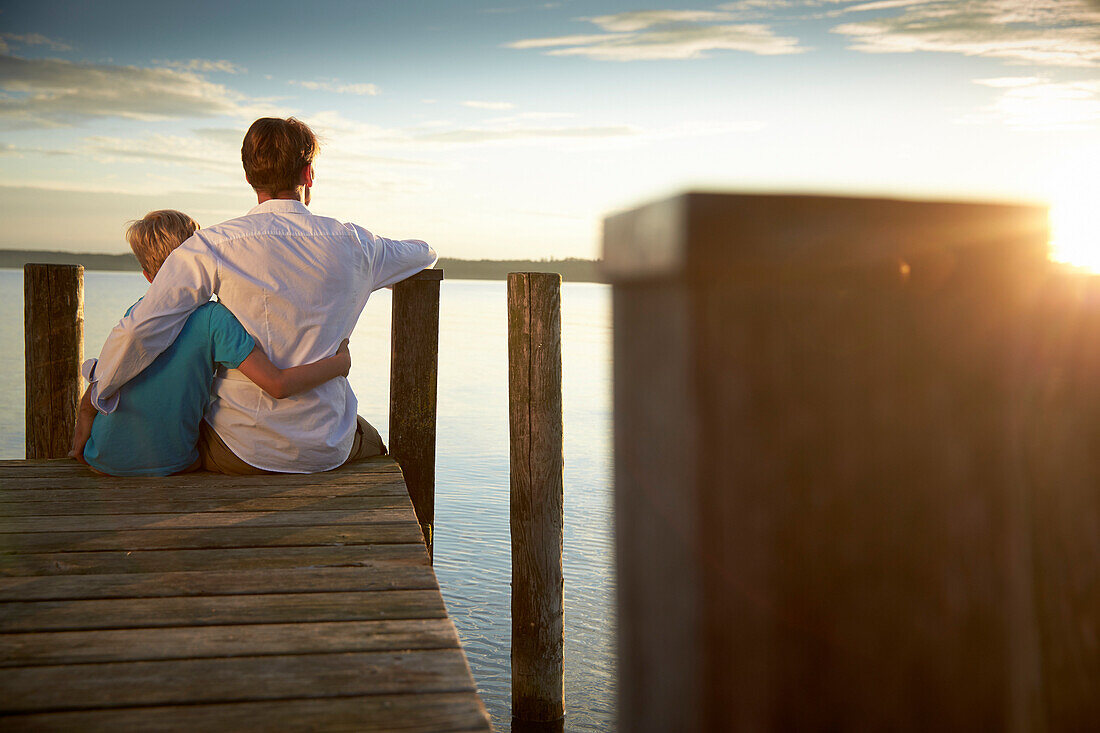 Father and son arm in arm on a jetty at Starnberger See, Oberbayern, Bayern, Deutschland