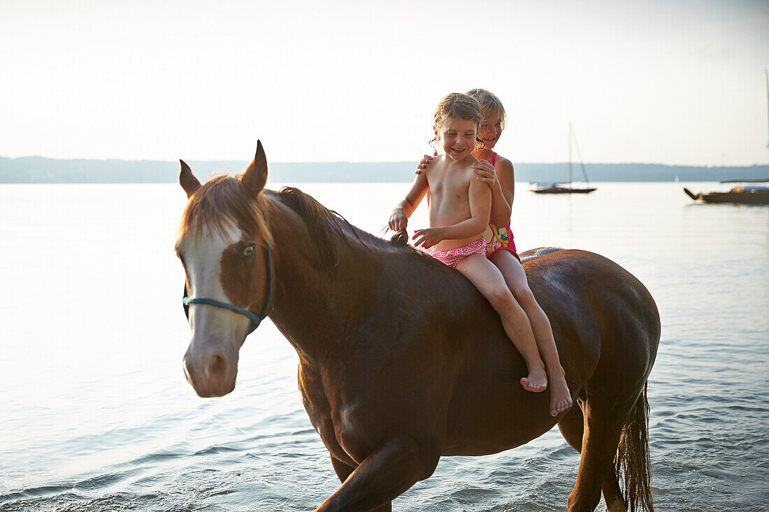 Two girls on horse back at lake Starnberg, Upper Bavaria, Bavaria, Germany