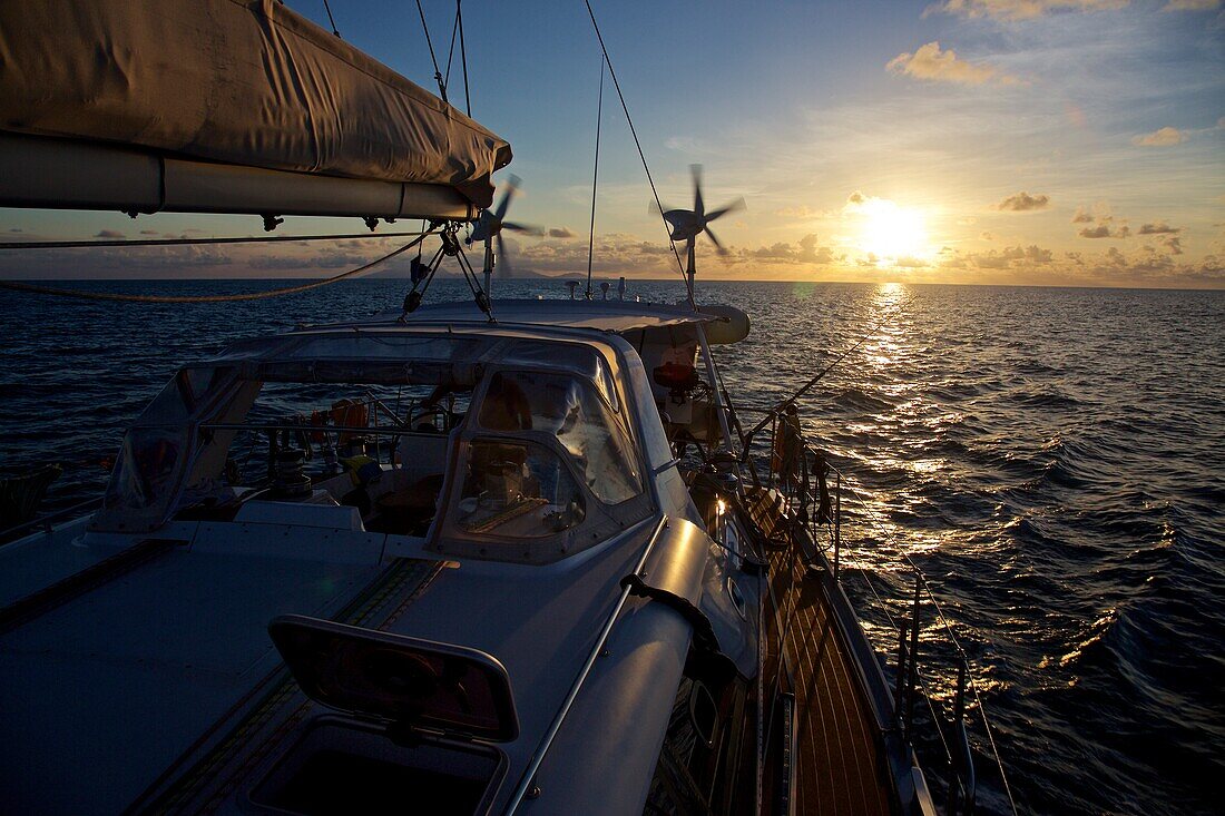 Wolkenstimmung bei Sonnenaufgang von einer Segelyacht mit Windgeneratoren in der Karibik