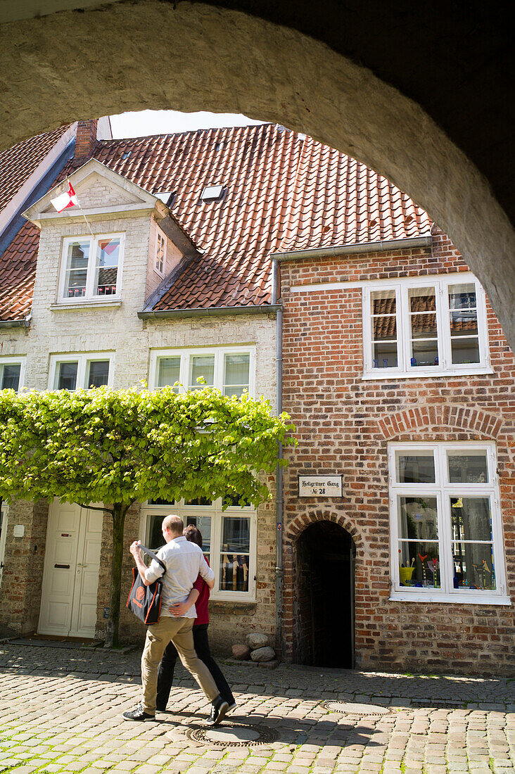 Couple strolling along street Engelswisch, historic city, Lubeck, Schleswig-Holstein, Germany