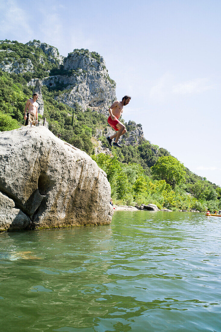 Mann springt von einem Felsen ins Wasser, Heraultschlucht, Saint-Bauzille-de-Putois, Ganges, Herault,  Languedoc-Roussillon, Frankreich