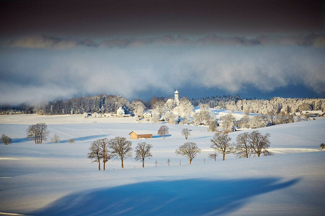 Blick auf Holzhausen mit Pfarrkirche St. Johann Baptist im Winter, Holzhausen, Münsing, Oberbayern, Bayern, Deutschland