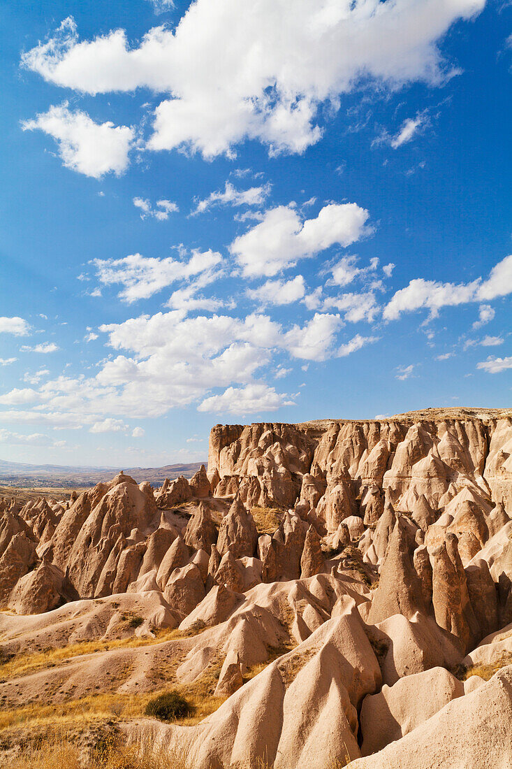 'Fairy chimneys and cliffs in a rugged, barren landscape in Deverent Valley; Cappadocia, Turkey'