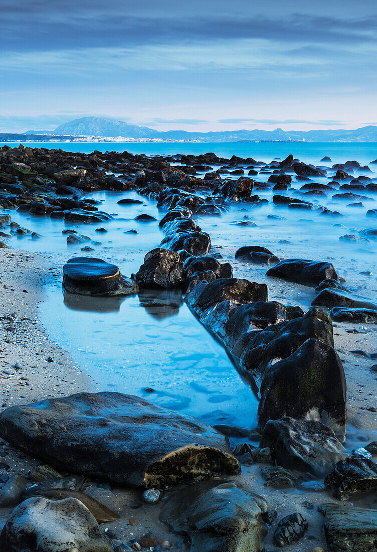 'Wet rocks along the shoreline; Tarifa, Costa de la Luz, Cadiz, Andalusia, Spain'