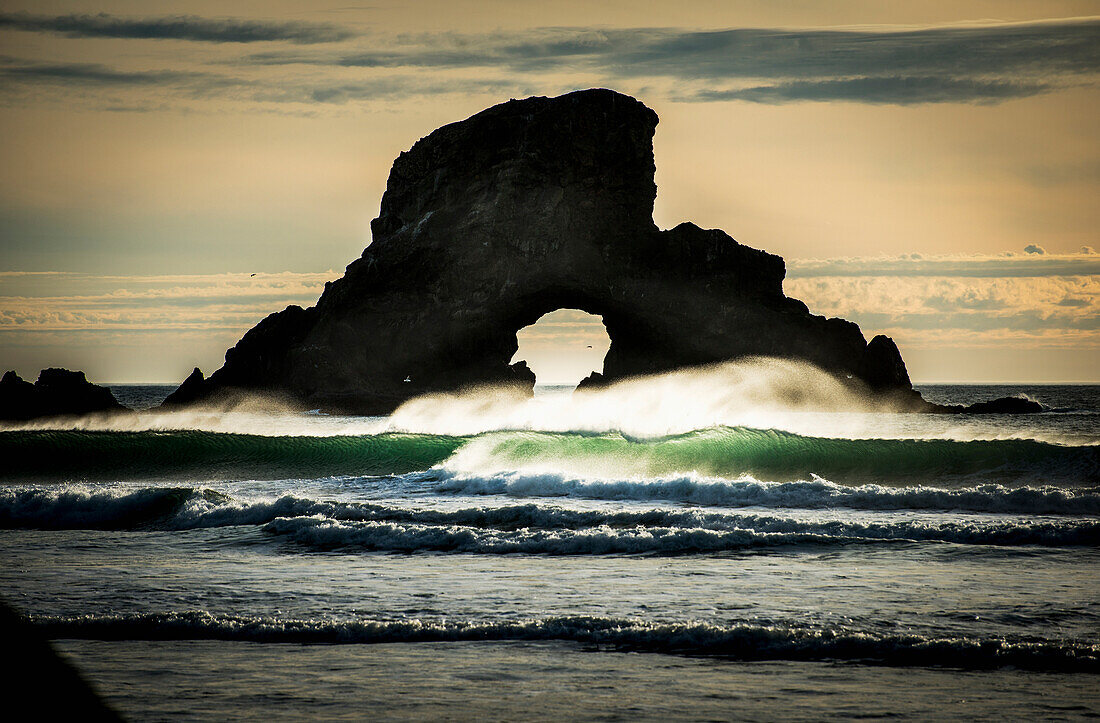 'Surf breaks near a natural arch; Cannon Beach, Oregon, United States of America'