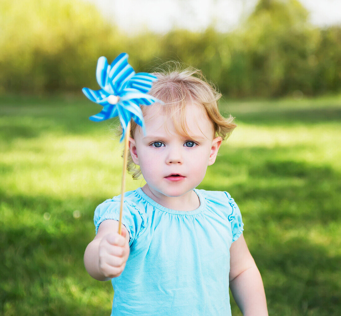 'Young girl with pinwheel in a park; Edmonton, Alberta, Canada'