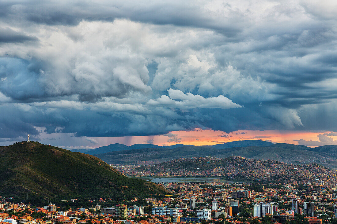 'The skies turn stormy over the skies of Cochabamba, with El Cristo seen on the mountain in the middle of the city; Bolivia'