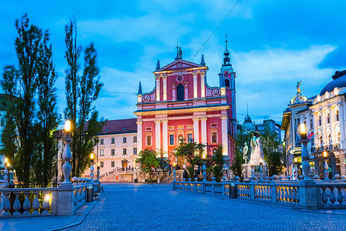 Ljubljana at night. Franciscan Church of the Annunciation seen from the Triple Bridge (Tromostovje), Ljubljana, Slovenia, Europe