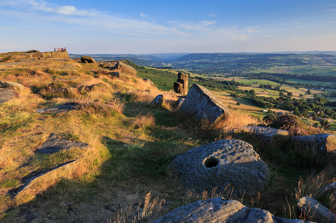 Friends on Curbar Edge with boulders and a millstone in summer, Peak District National Park, Derbyshire, England, United Kingdom, Europe