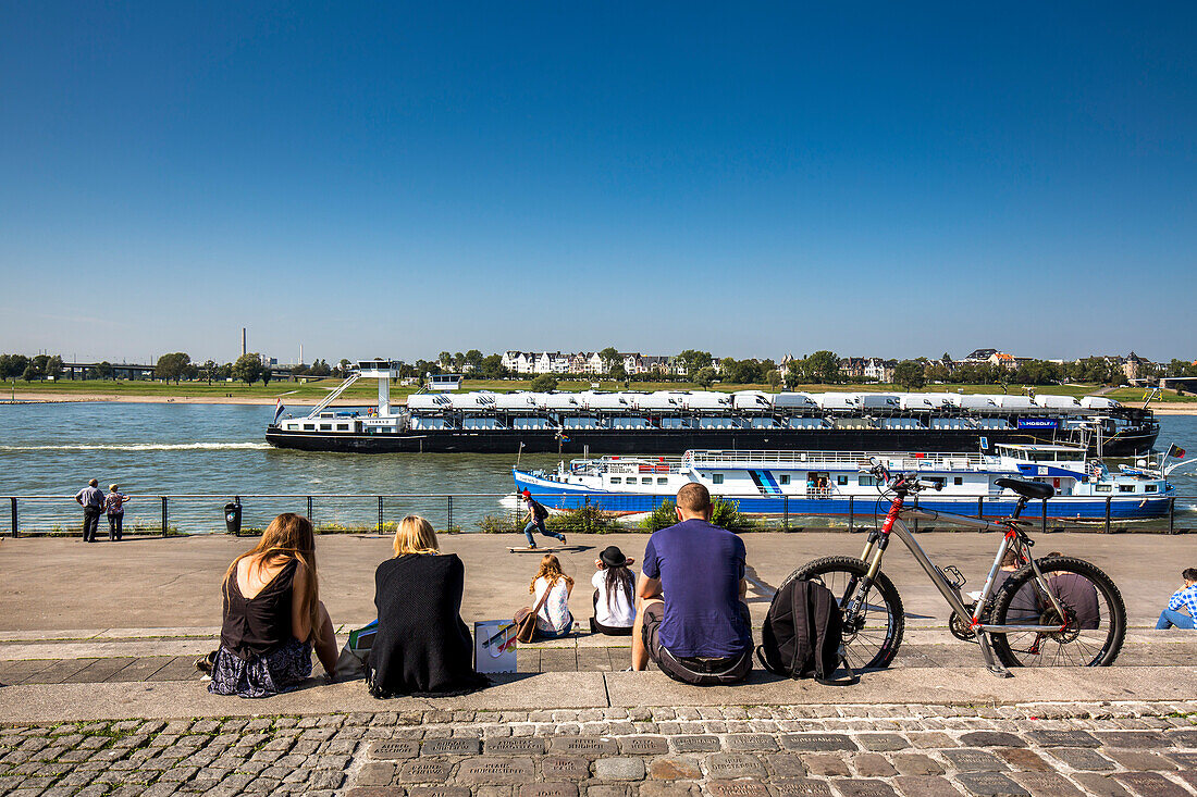 People sitting along the Rhine promenade, Duesseldorf, North Rhine Westphalia, Germany