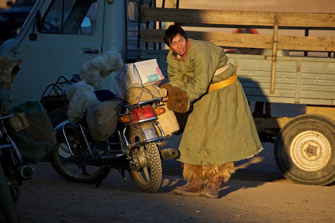 Mongole mit Motorrad in traditioneller Winterkleidung, Mongolei