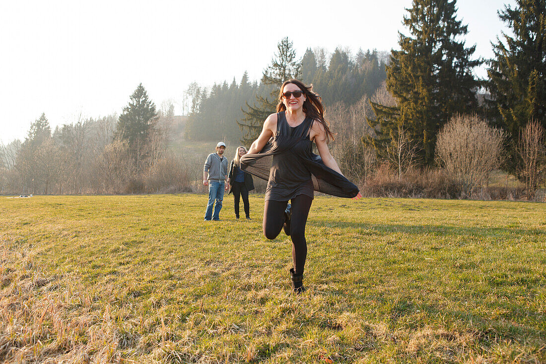 Junge Frau läuft über eine Wiese, Großer Alpsee, Immenstadt im Allgäu, Bayern, Deutschland