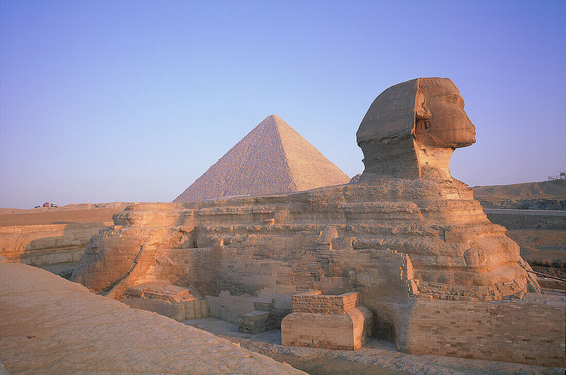 EGYPT.CAIRO.GIZEH.THE SPHINX AND PYRAMIDS AT BACK AT SUNRISE.