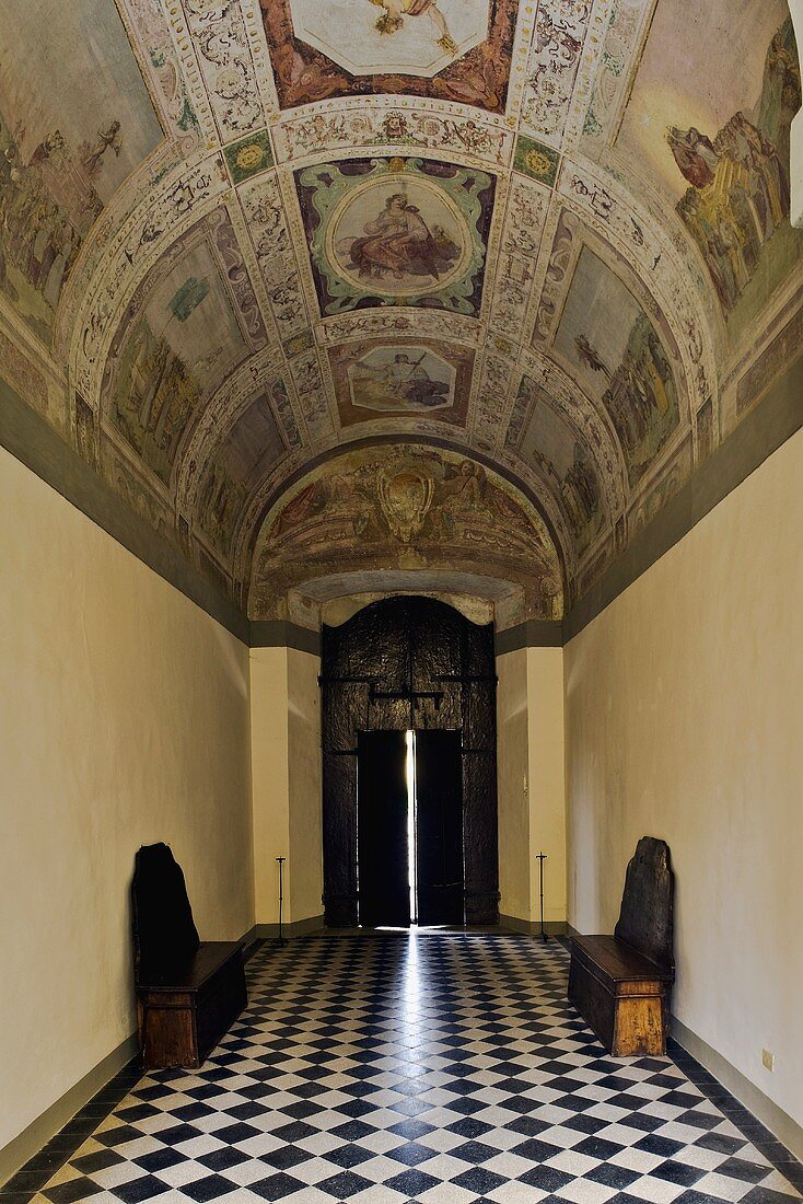 Impressive frescos painted on a barrel vault ceiling and floor with a checkerboard pattern