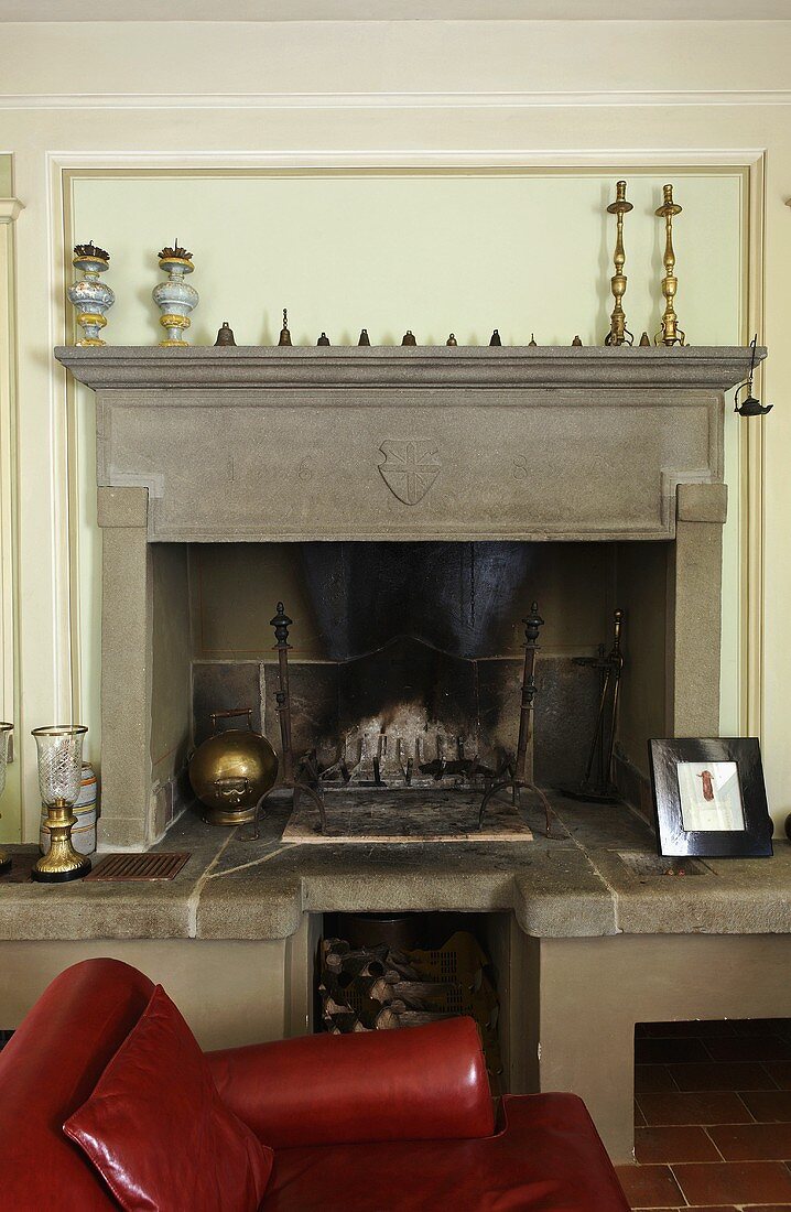 Red leather armchair in front of a fireplace clad in gray stone