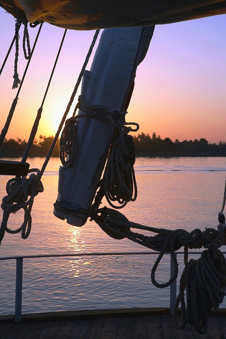 Blick durch Takelage eines Segelbootes auf Abendröte mit Sonnenuntergang, Nil, Ägypten