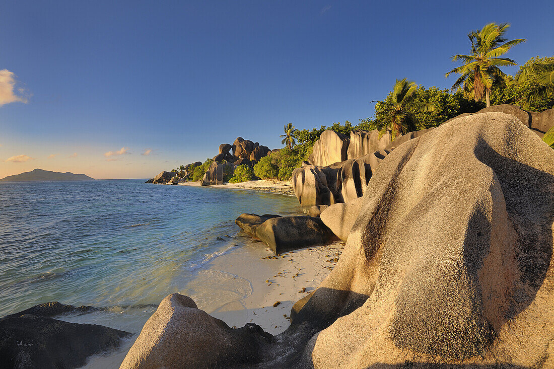 Famous beach Anse Source d'Argent with palm trees and sculpted rocks, La Digue Island, Seychelles, Indian Ocean.