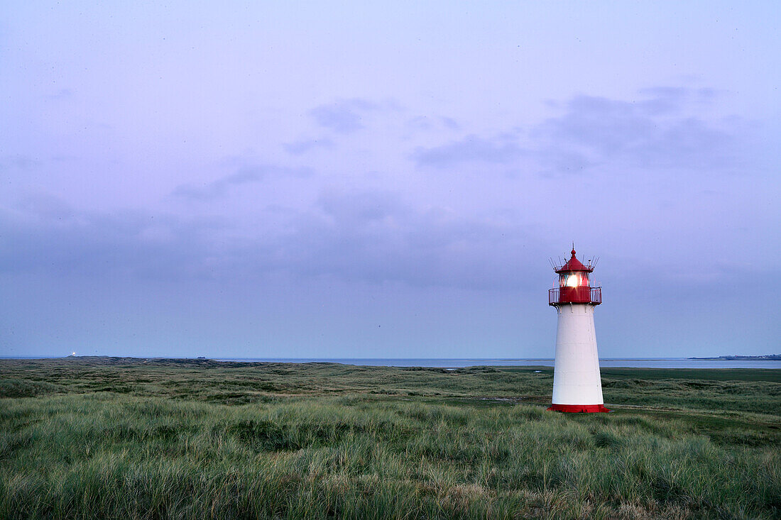 Lighthouse List West with light on in the dunes, with beach and North Sea, Sylt, North Frisian Islands, Schleswig-Holstein, Germany, Europe.