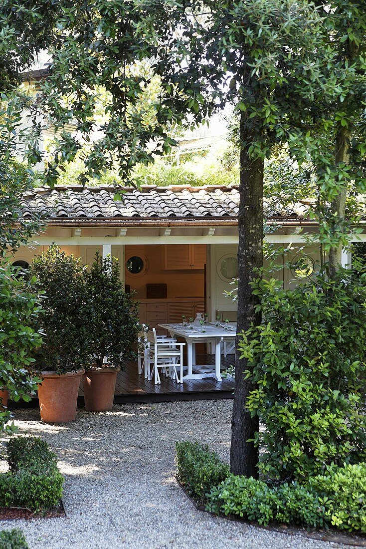 Landhaus mit Terrasse und Kiesboden im Garten