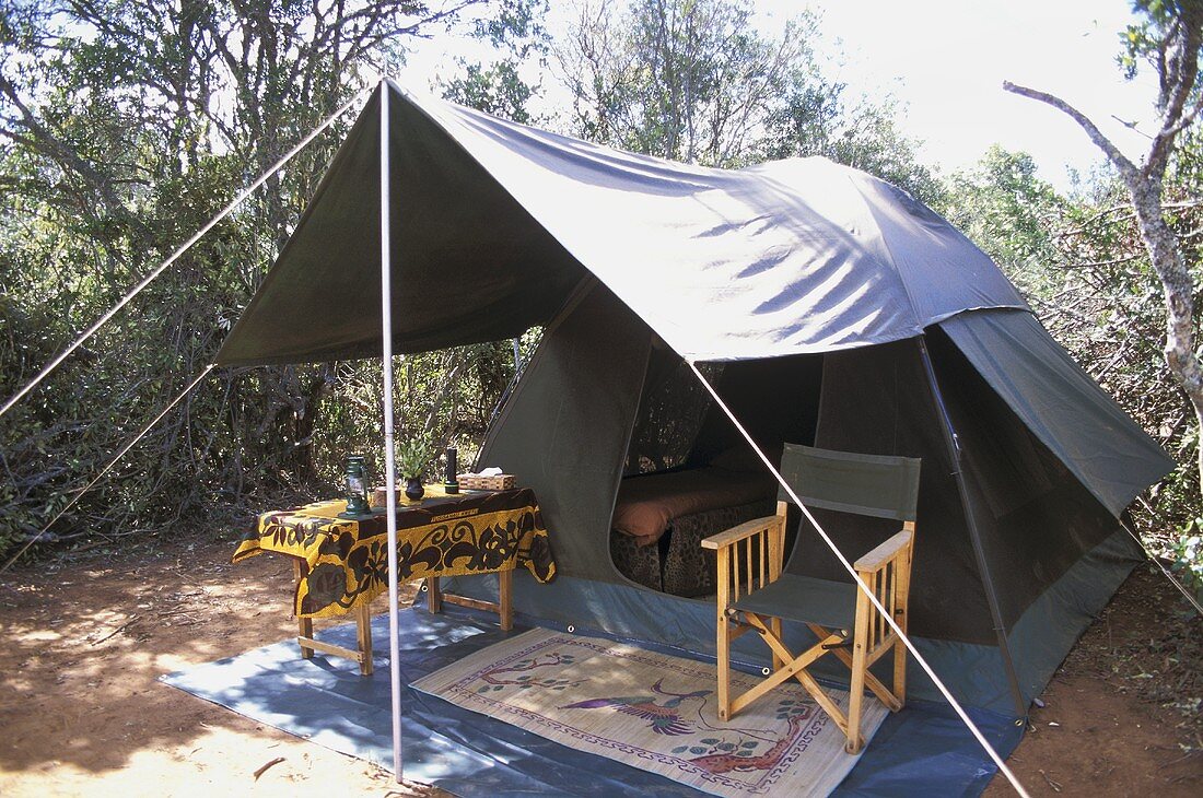 Wooden canvas chair and table under a tent canopy