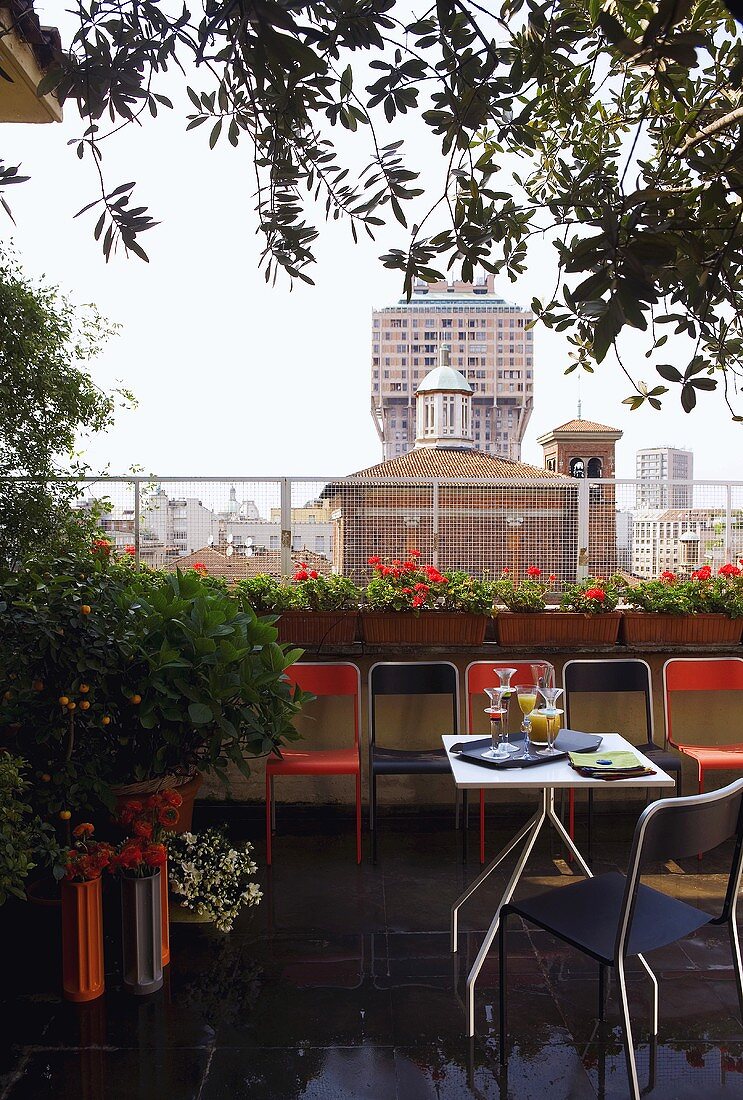 Feiern auf der Dachterrasse - Tische und Stühle auf regennassem Boden