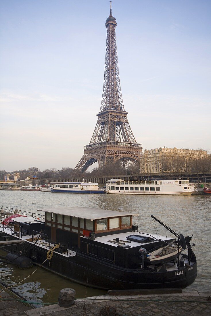 Sunny day in Paris - house boat docked on the bank with a view of the Eiffel tower