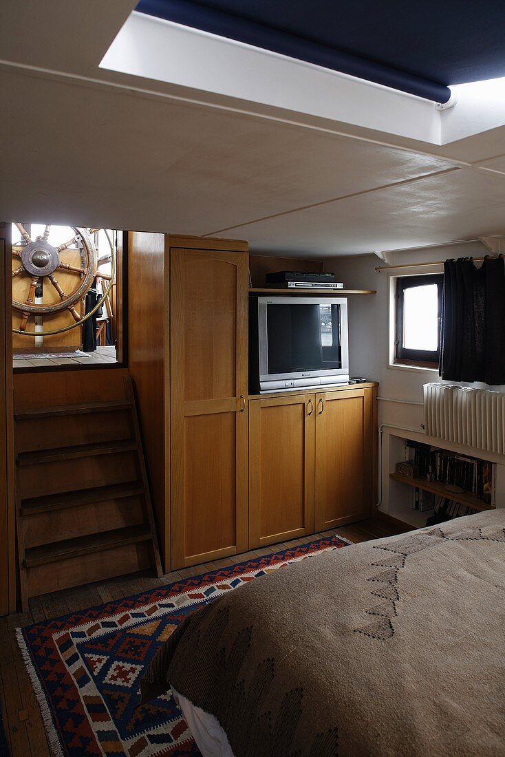 Schlafkabine im Hausboot mit Einbauschrank und Treppe mit Blick auf Steuerrad