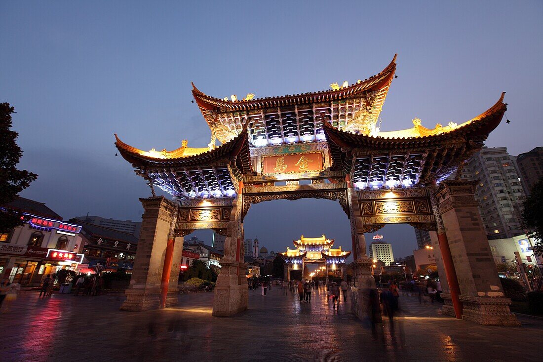 Night view of memorial arches of the Golden Horse and Jade Rooster in Jinmabiji Square, Kunming, China