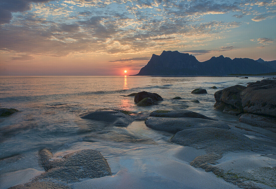 the midnight sun over the Arctic from Uttakleiv Beach in the Lofoten Islands, Norway.