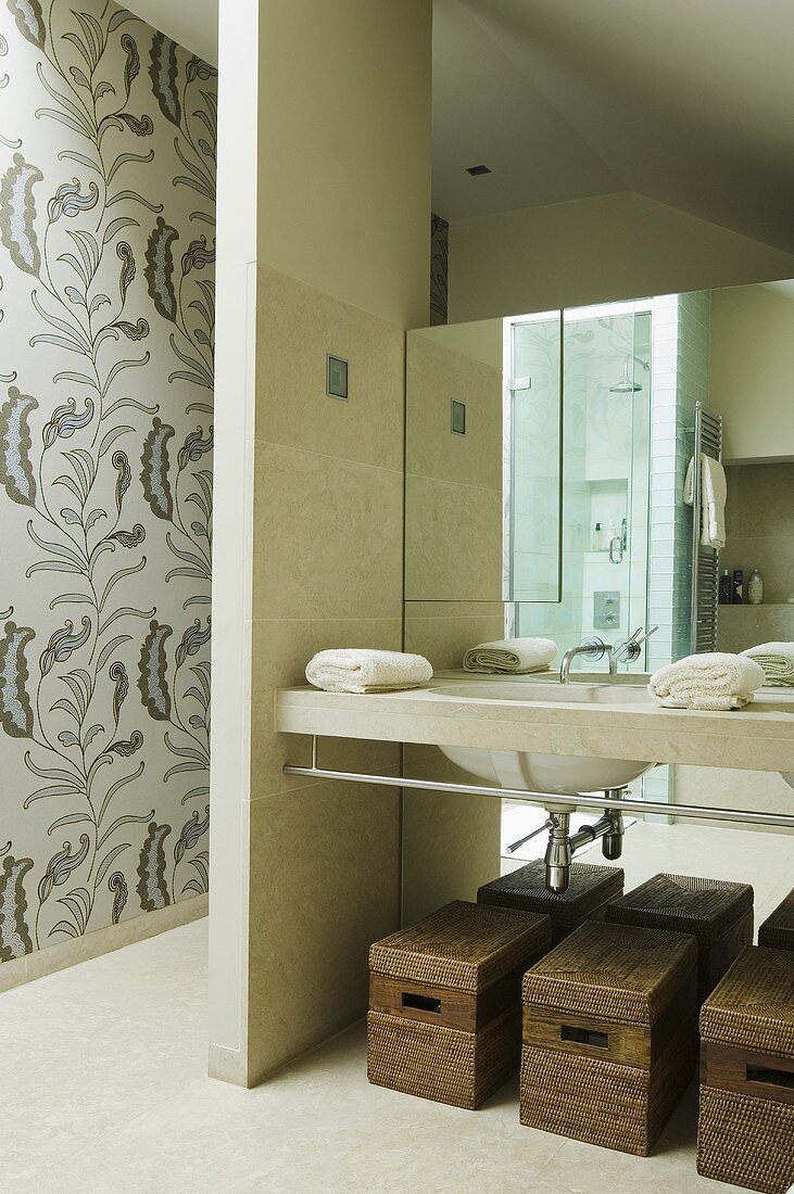 Offener Waschbereich - Waschtisch mit Körben auf Boden vor Spiegelfront und Wandscheibe an der Seite