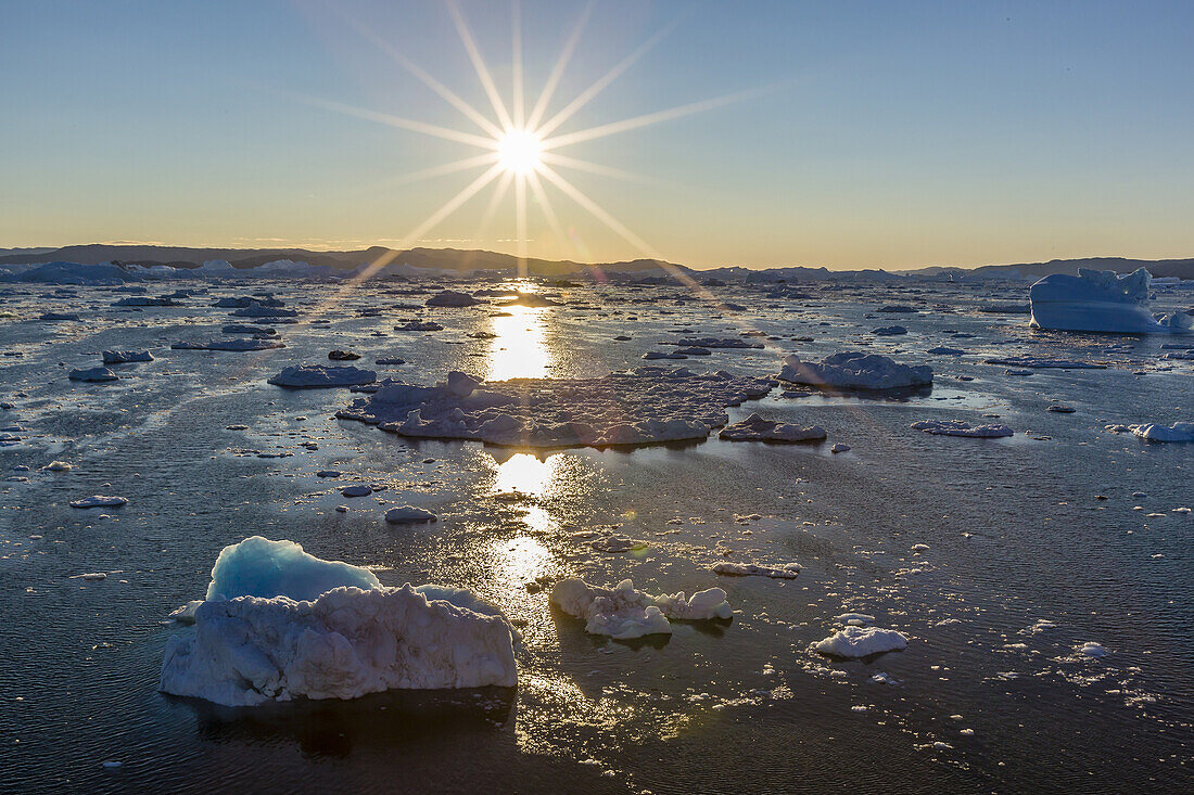 Sunset over icebergs calved from the Ilulissat Glacier, a UNESCO World Heritage Site, Ilulissat, Greenland.
