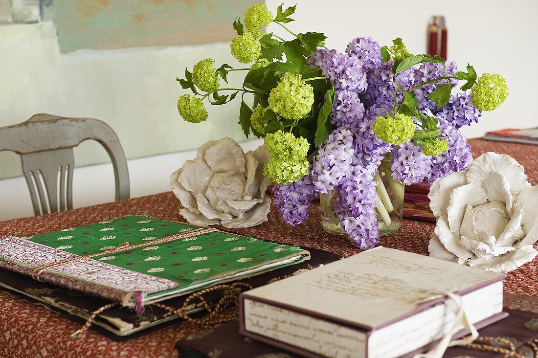 A bunch of lilac and colourful folders on a table with a patterned tablecloth