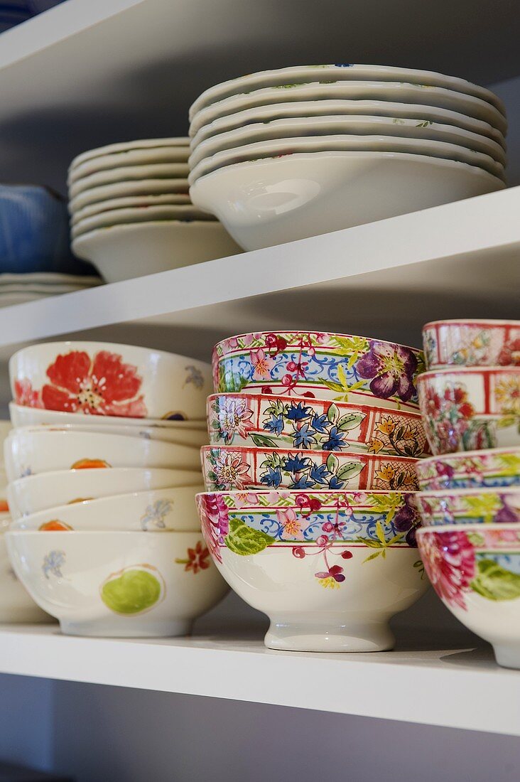 Brightly painted bowls and plates on a white shelf