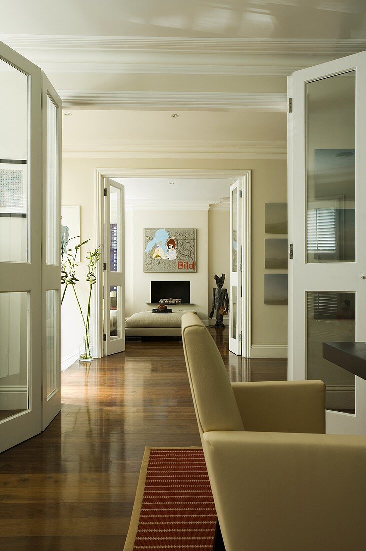 A suite of rooms - open glass doors and continuous parquet floor in a dining room and a living room