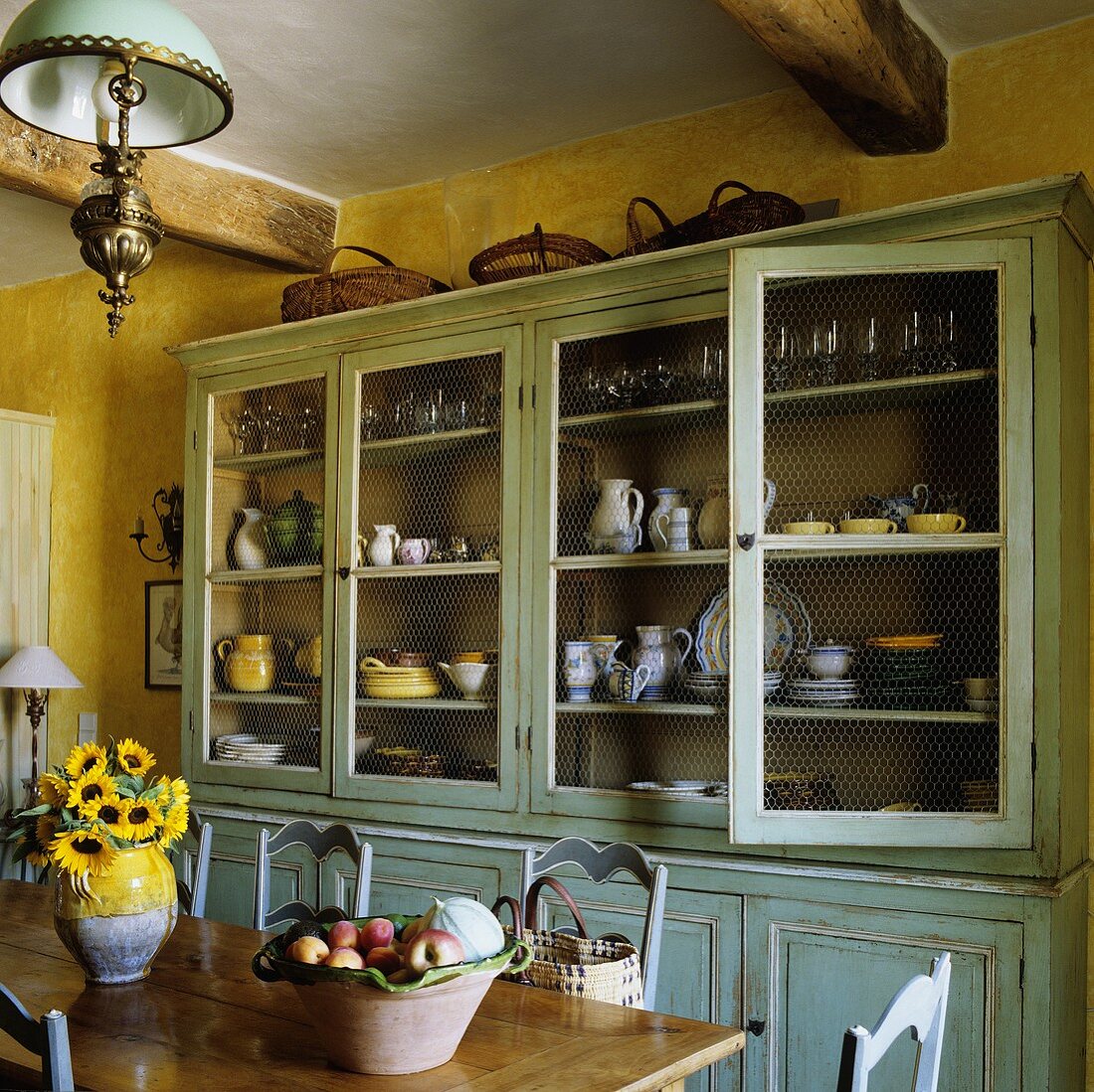 A yellow-painted kitchen with a light blue vintage dresser