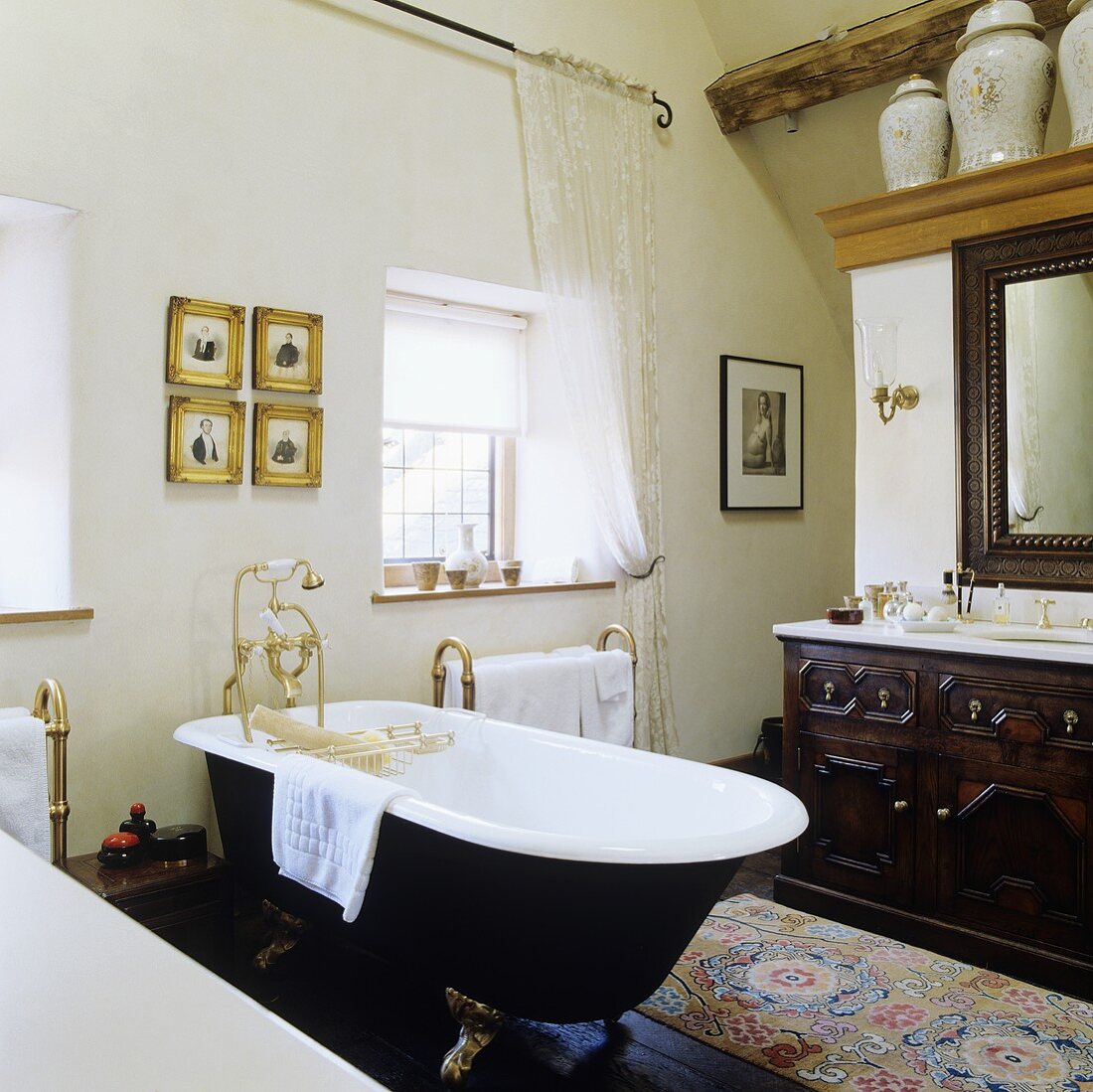 A bathroom in a country house with a freestanding bath tub with feet and brass taps