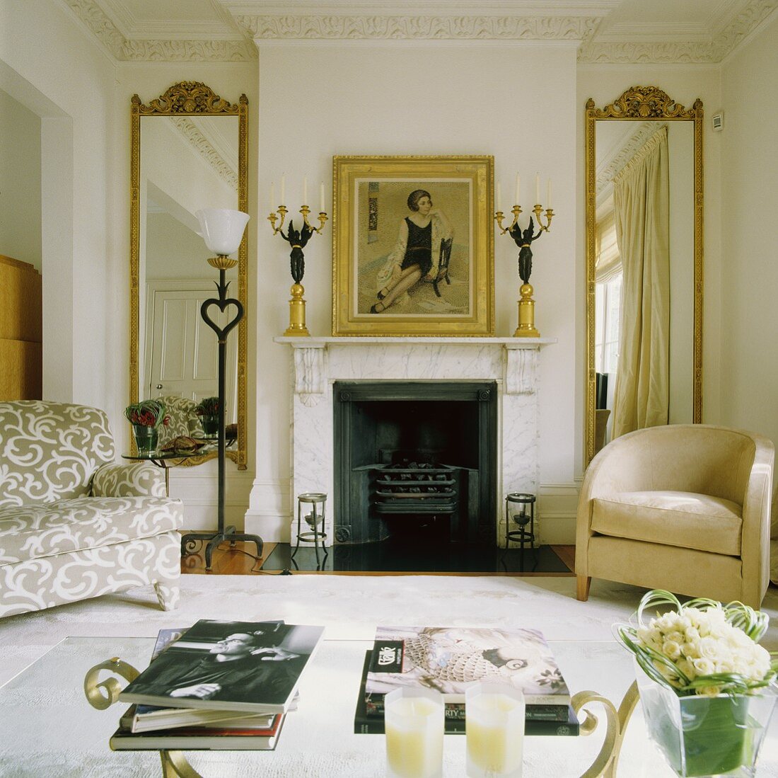 A living room with a fireplace and a comfortable upholstered armchair in front of a floor-to-ceiling mirror with a gold frame