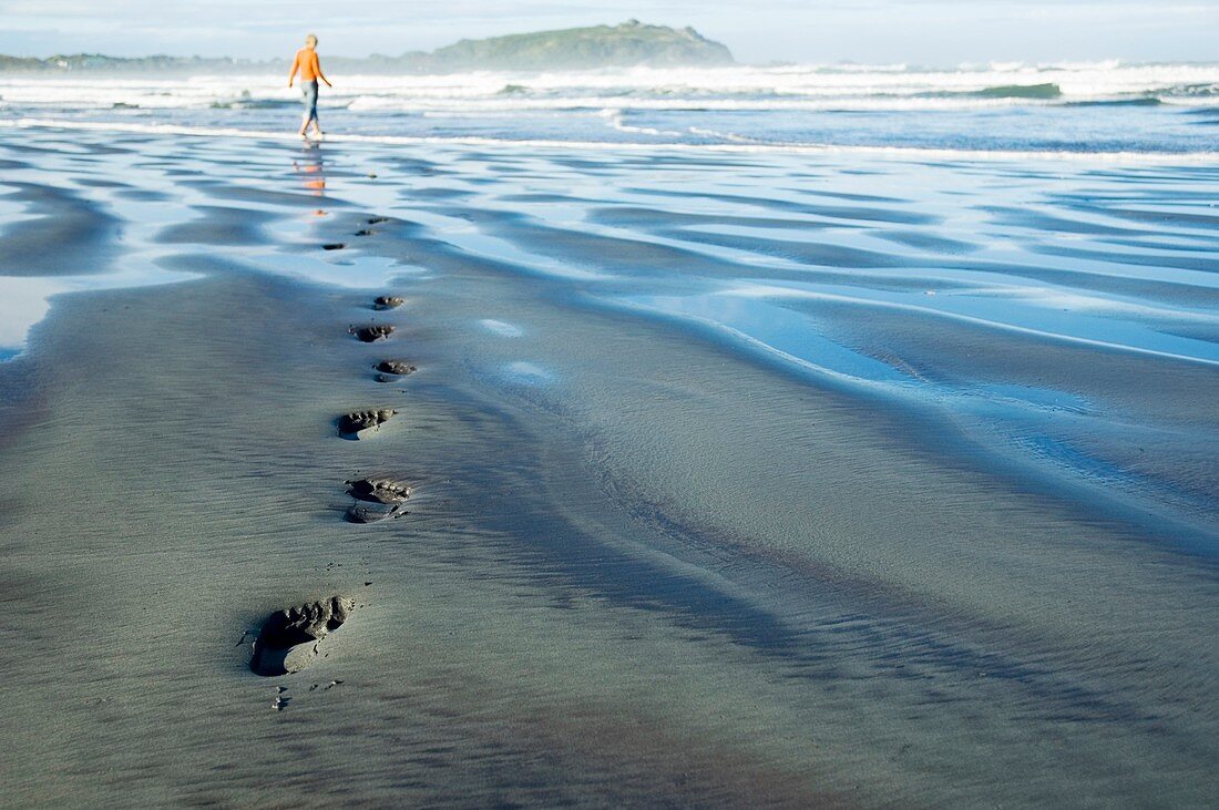 Footprints in sand on beach, west coast, New Zealand