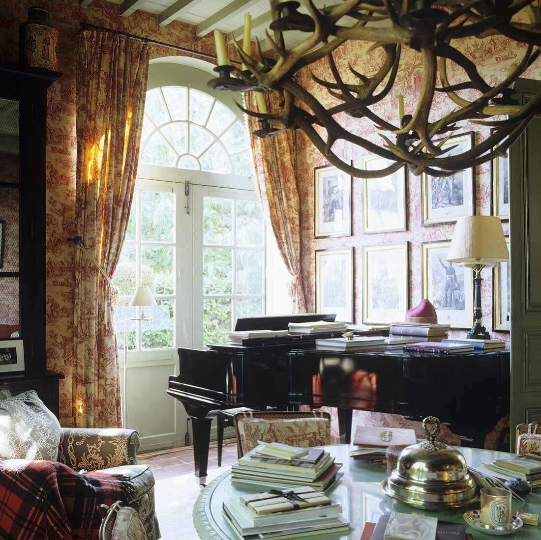 A piano in front of arched terrace doors in a French country house