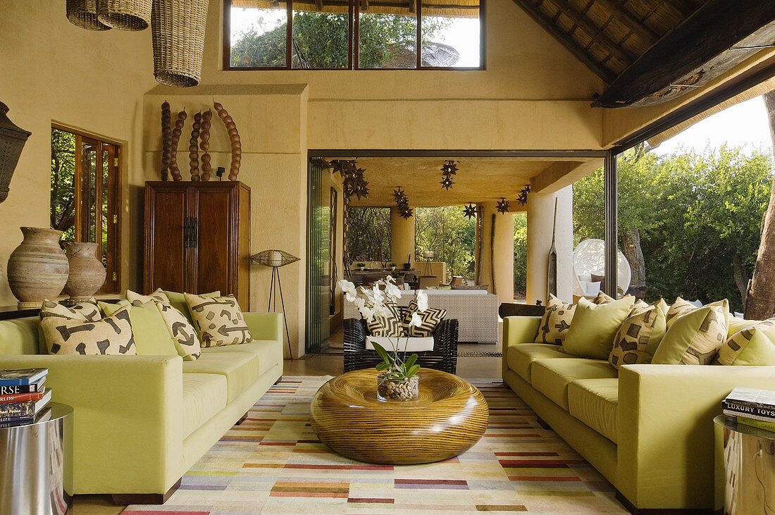 A light green sofa and a wooden floor table in front of a window in a South African villa
