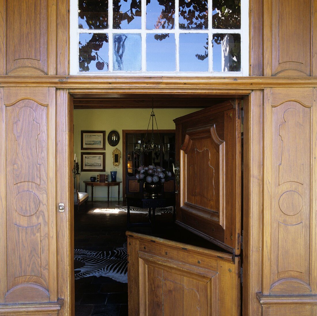 A front door with open shutters and a view into a living room