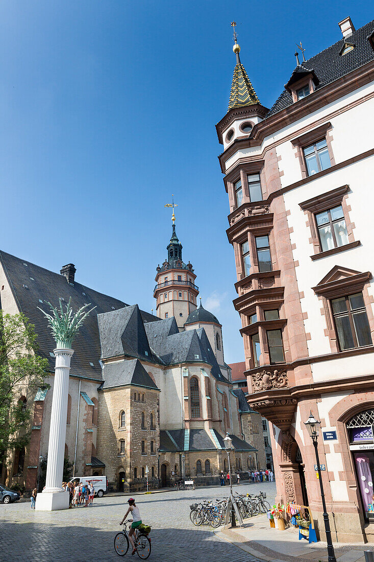 Saint Nicholas Church, square Nikolaikirchhof, women cycling, bicycle, pillar Nikolaisaeule, here started the Monday Demonstrations and the Peaceful Revolution of 1989, city centre, Leipzig, Saxony, Germany, Europe