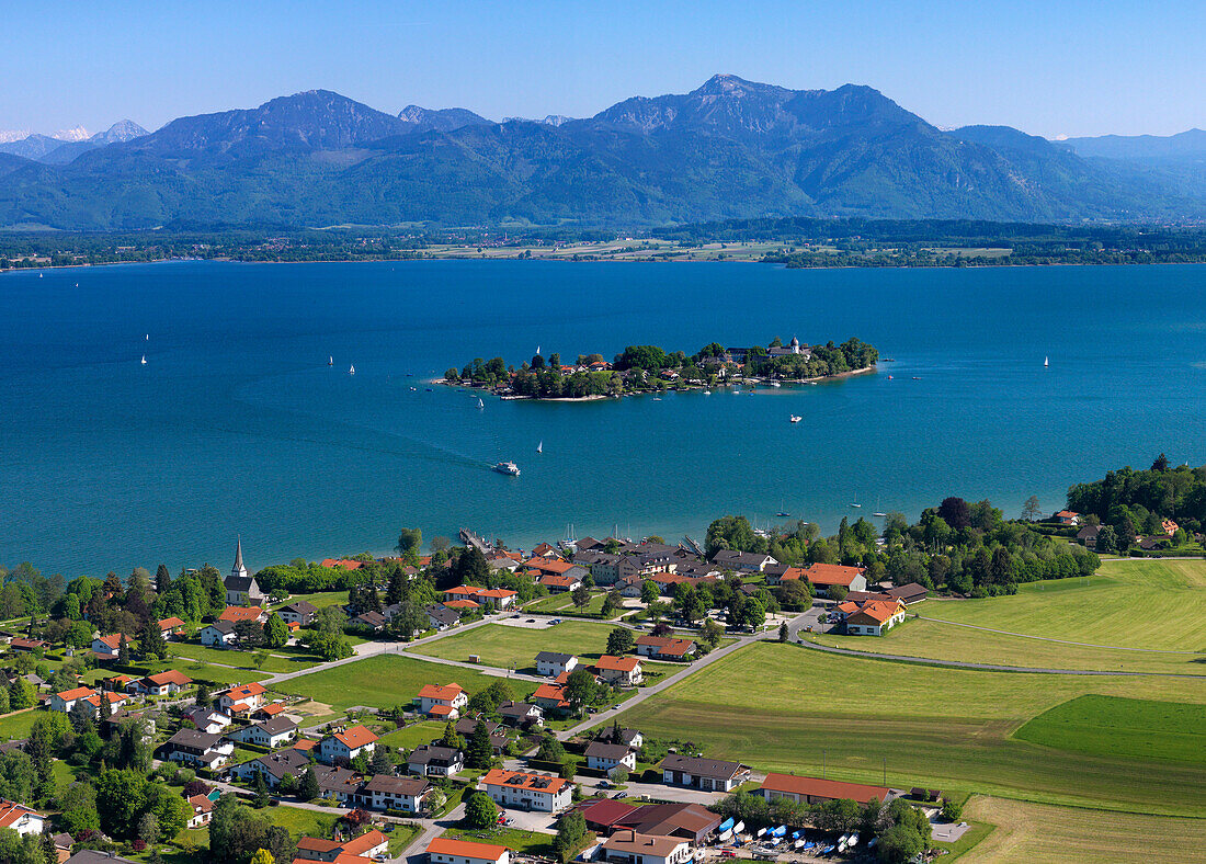 Aerial shot of Gstadt am Chiemsee, Fraueninsel and the mountains Hochfelln and Hochgern in background, lake Chiemsee, Bavaria, Germany