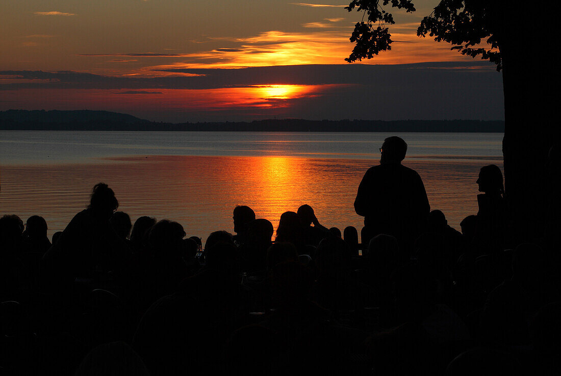 People in the evening at lake Chiemsee, Chieming, Bavaria, Germany