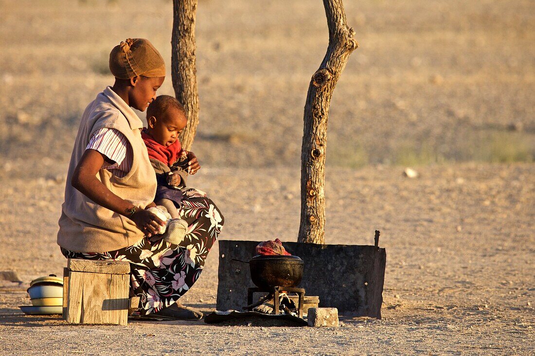 Herero Frau mit Kind an einer Kochstelle, Sesfontain, Namibia