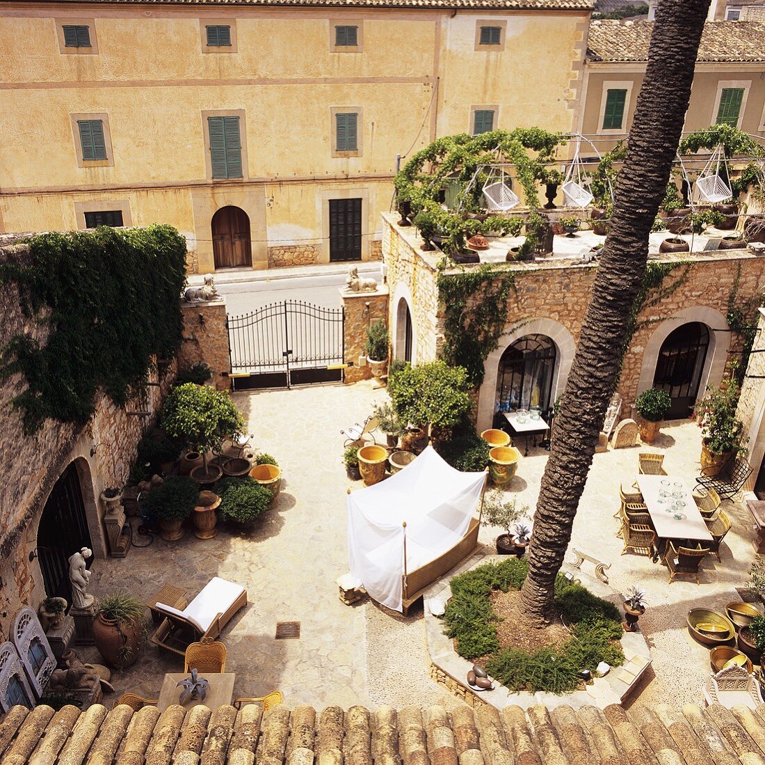 A courtyard of a Mediterranean manor house with terrace furniture and antiques