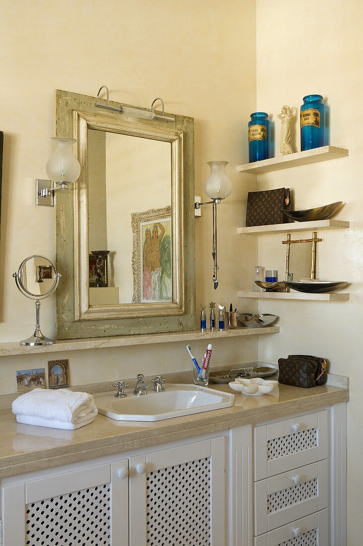 Corner of a bathroom in a country house - marble counter top with a basin and a mirror