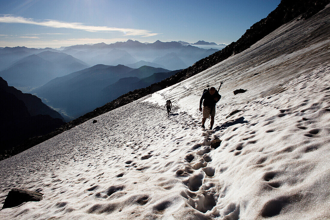 Two people hiking on a snowfield, ascend to Habicht (3277 m), Stubai Alps, Tyrol, Austria