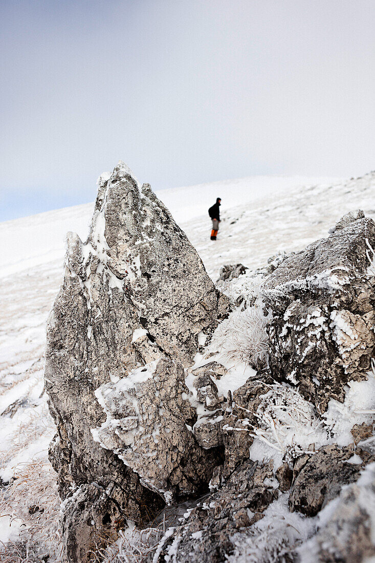 Wanderer steht in verschneiter Landschaft, Aufstieg zum Unnütz (2078 m), Rofan, Tirol, Österreich