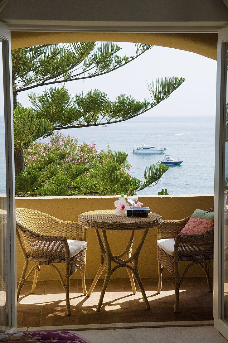 Wicker furniture on a balcony with a view of the sea